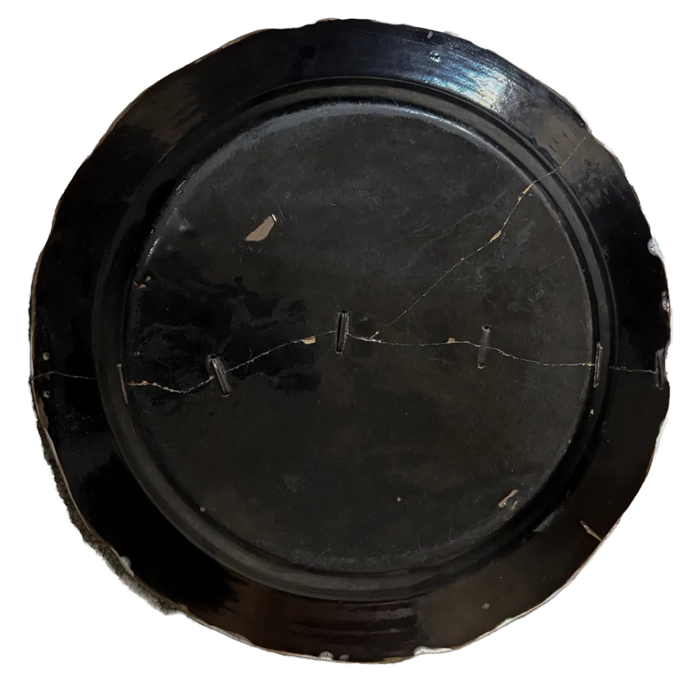 French faience charger with rivet repairs, from the collection of Tomas Brown