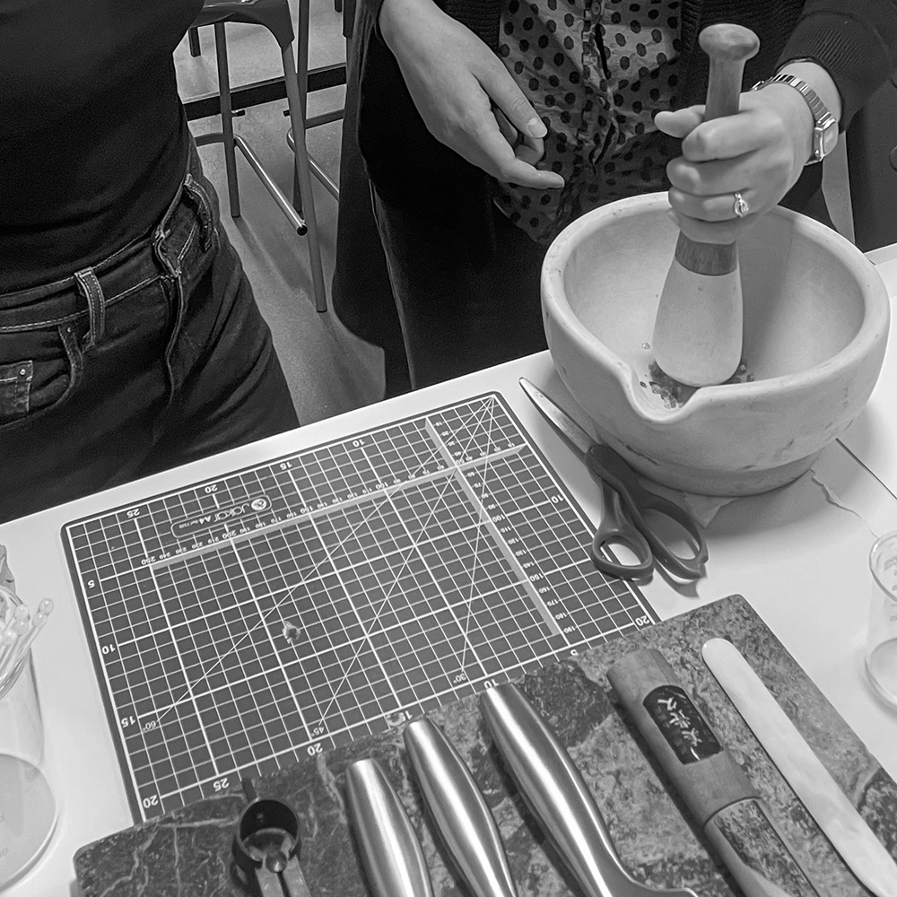 Crushing gum arabic with a pestle
